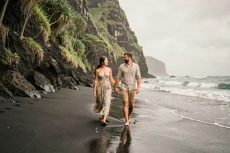 Couple en lune de miel se promenant sur une plage de sable noir à Hawaï
